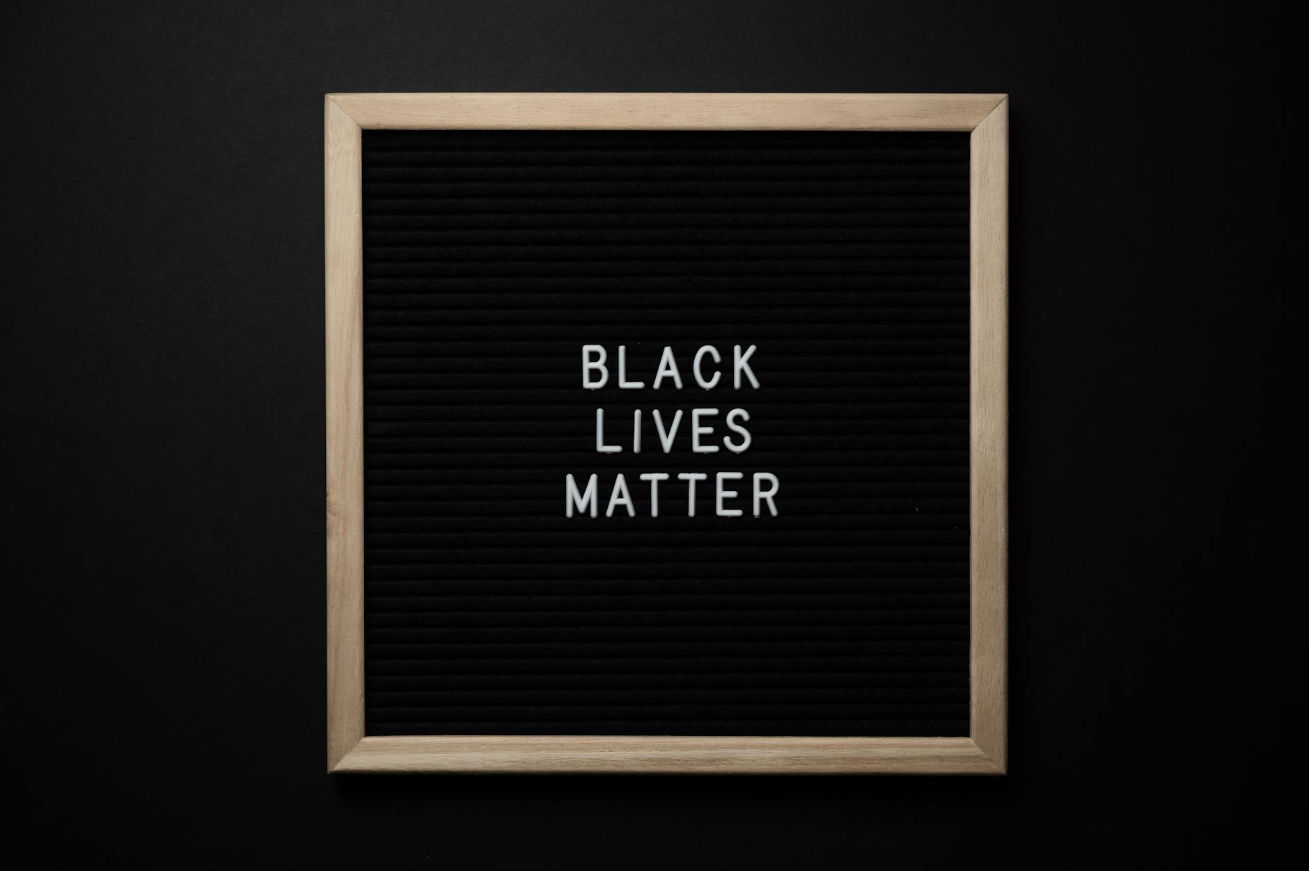 Black Lives Matter in white text on black background in a lighter frame on a black background. Photo by Brett Sayles via Pexels.com